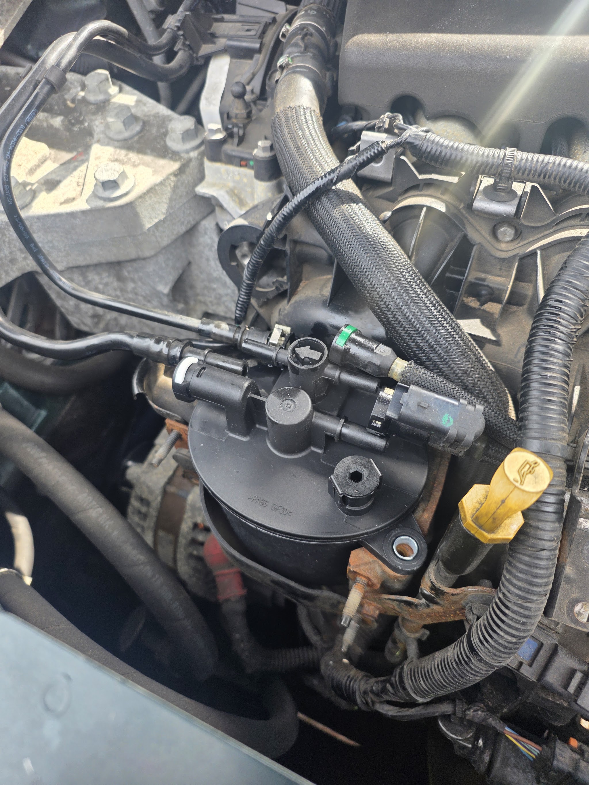 Close-up of an engine bay with pipework and a filter housing